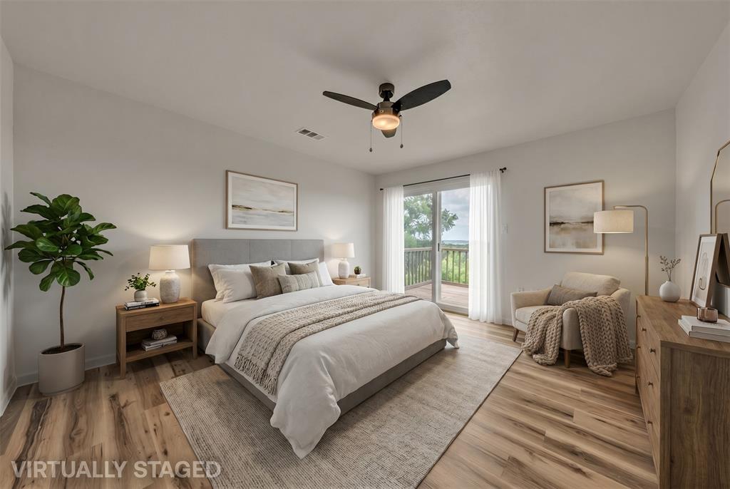 Wood-finish flooring, ceiling fan with integrated lighting, and glass sliding doors providing exterior access