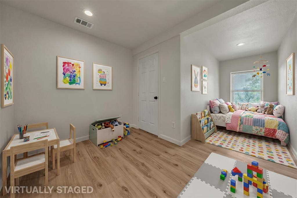 Neutral-toned room featuring wood-finish flooring, recessed lighting, and a window with horizontal blinds