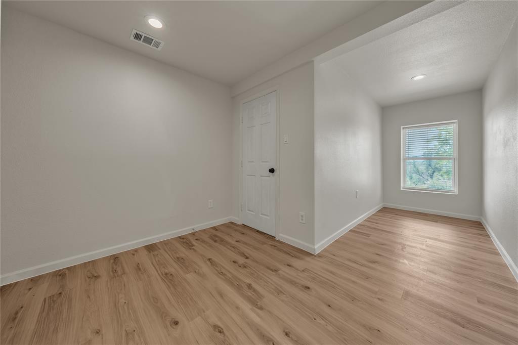 Interior room featuring light-toned wood-finish flooring, recessed lighting, and a six-panel door