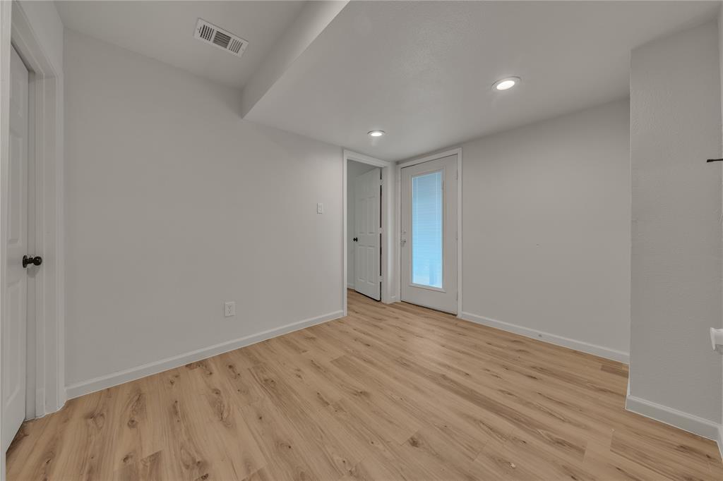 Interior space featuring wood-finish flooring, recessed lighting, and a glass-paneled exterior door