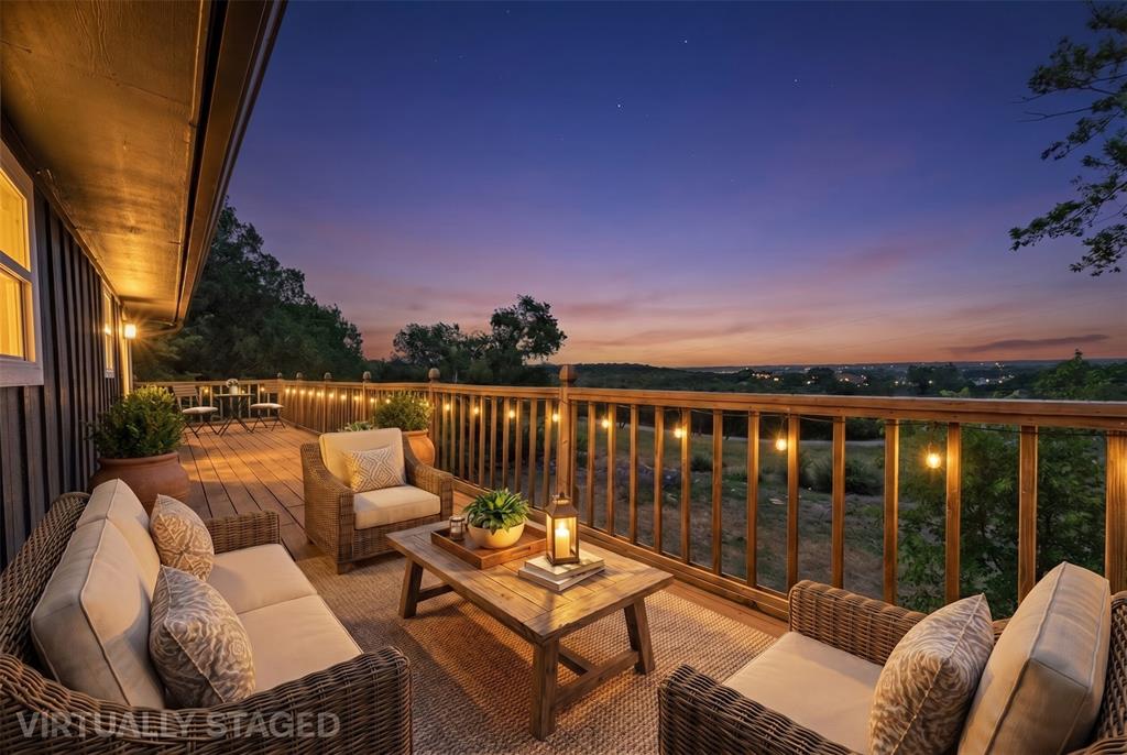 Expansive wooden deck featuring horizontal plank flooring, vertical timber railing, and perimeter string lighting