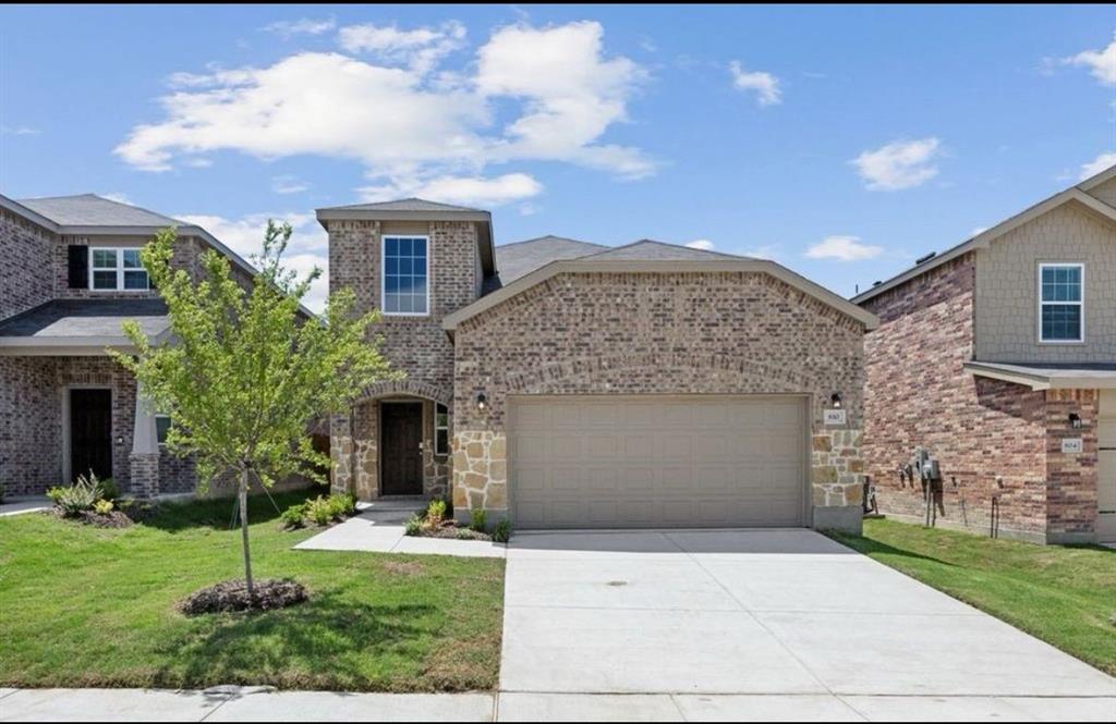 Exterior facade featuring a combination of brick and stone masonry, concrete driveway, and attached two-car garage Exterior facade featuring a combination of brick and stone masonry, concrete driveway, and attached two-car garage