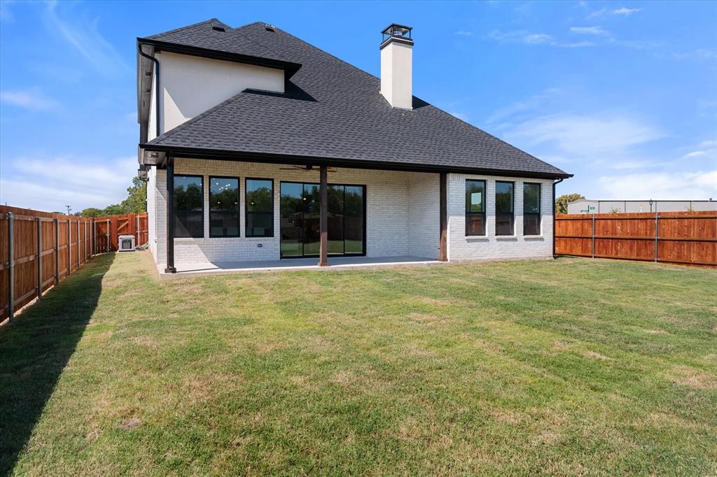 Back exterior featuring a covered patio, stained fence