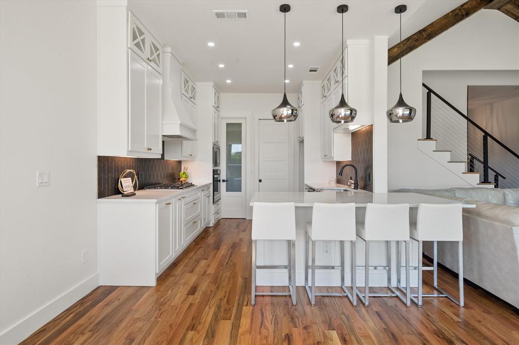 Kitchen featuring 42" custom cabinets, oak wood, recessed lighting, modern pendant lighting and Whirlpool appliances