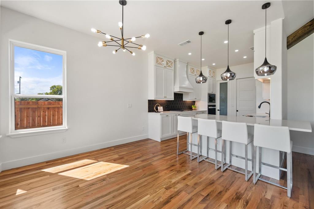 Eat in kitchen area with a Quartz extended countertop, modern pendant lighting and gleaming Oak wood floors