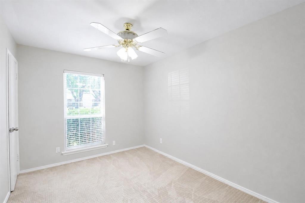 Neutral wall tones, wall-to-wall carpeting, single-hung window with blinds, and a multi-blade ceiling fan with integrated light fixture