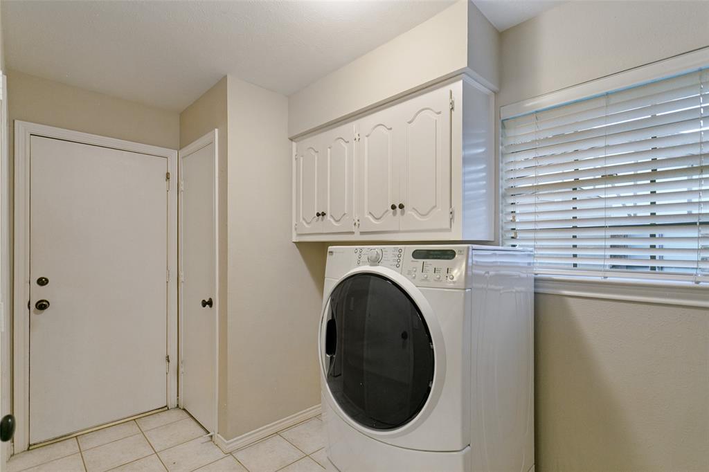 Large laundry room with window, cabinets, hanging rod, drip-dry