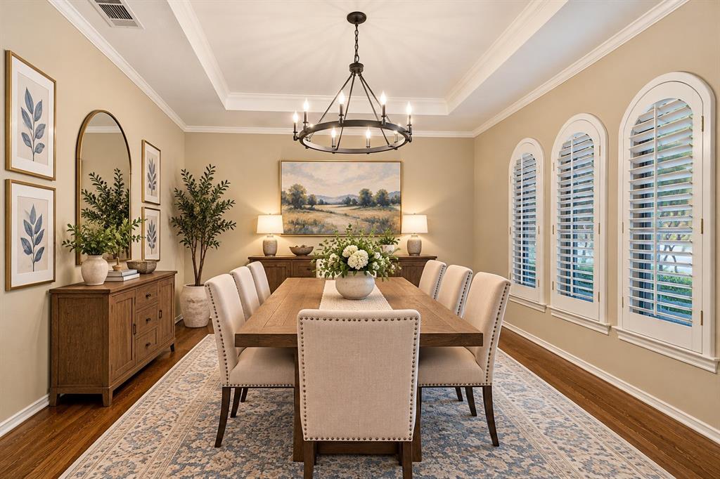 Timeless hardwood flooring in formal dining along w white shutters, chandelier and crown molding - virtual staging
