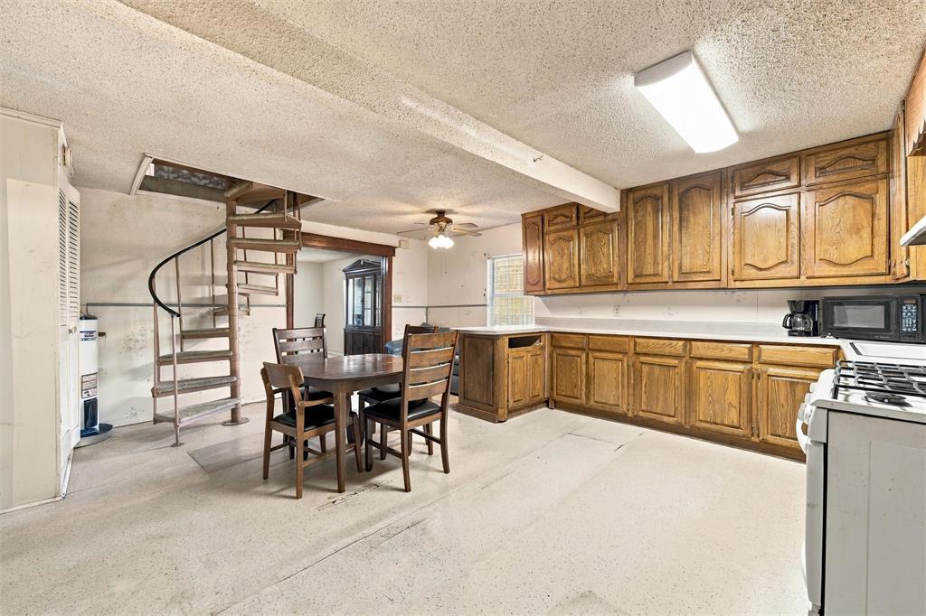 Kitchen featuring wood cabinetry, integrated gas range, and spiral metal staircase