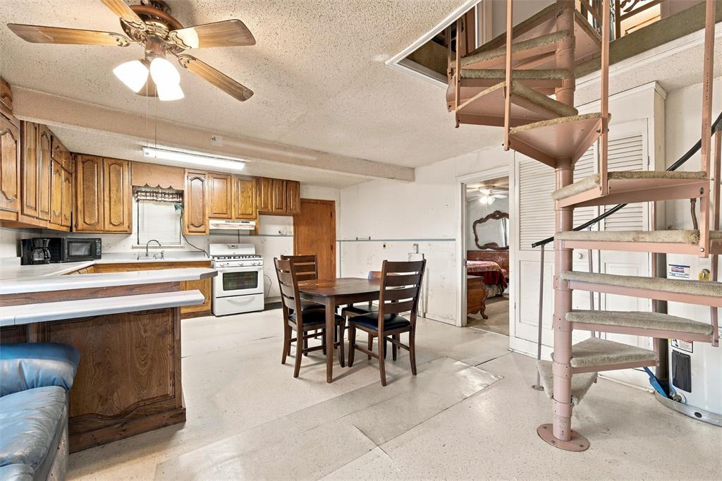 Kitchen featuring custom wood cabinetry, a peninsula counter, and a metal spiral staircase with treads