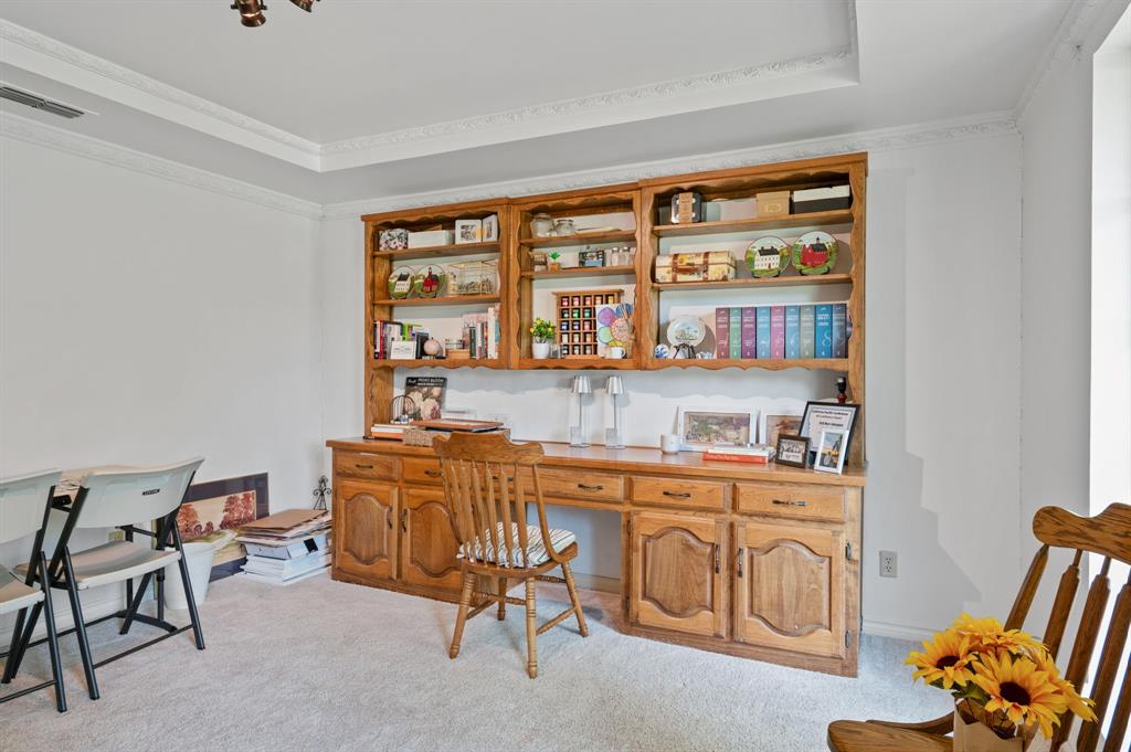 Custom built-in oak desk and shelving unit, tray ceiling, and crown molding