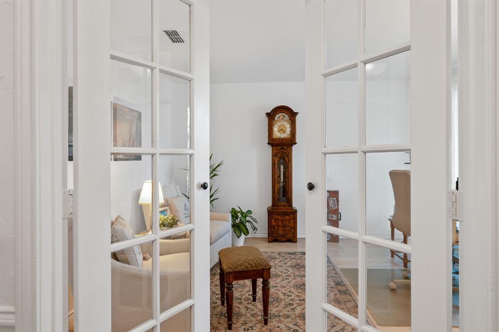 White-framed French doors featuring glass panes and black hardware