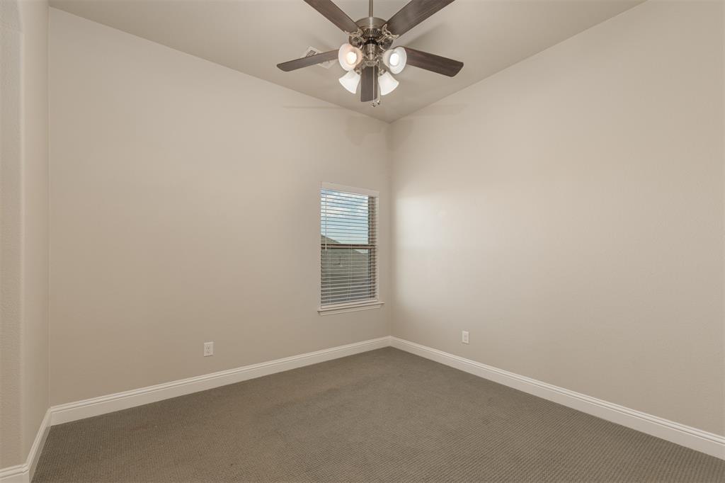 Neutral-toned room featuring textured carpeting, a multi-light ceiling fan with dark wood-finish blades, and a single window with horizontal blinds