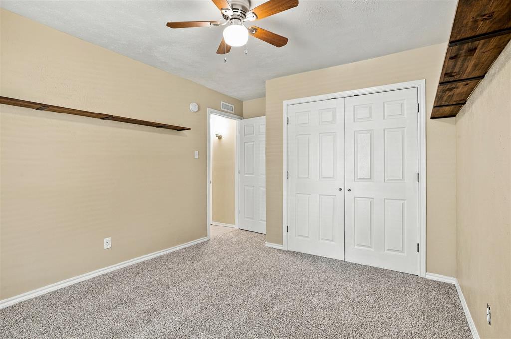 Bedroom with carpeted flooring, neutral finishes, a ceiling fan, and an open layout