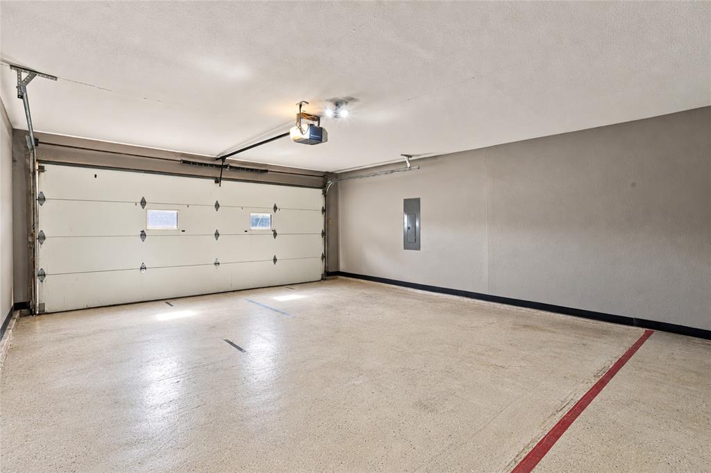 Spacious two-car garage featuring a concrete floor, overhead garage door, and additional room for storage.