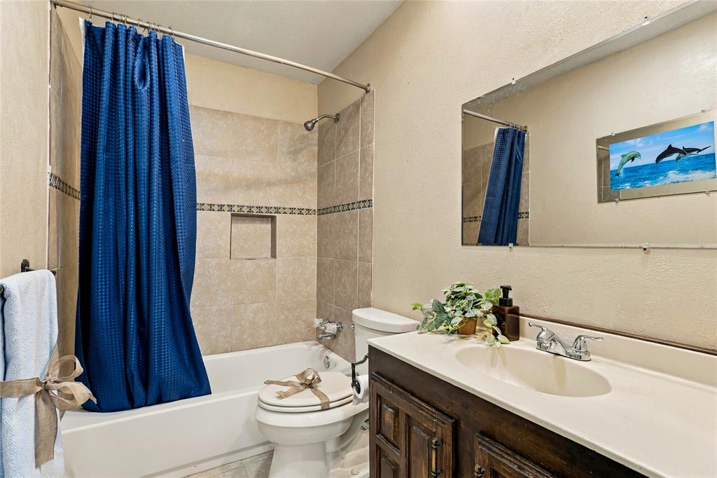 Full bathroom featuring a bathtub and shower combination, vanity with countertop, and neutral tile finishes.