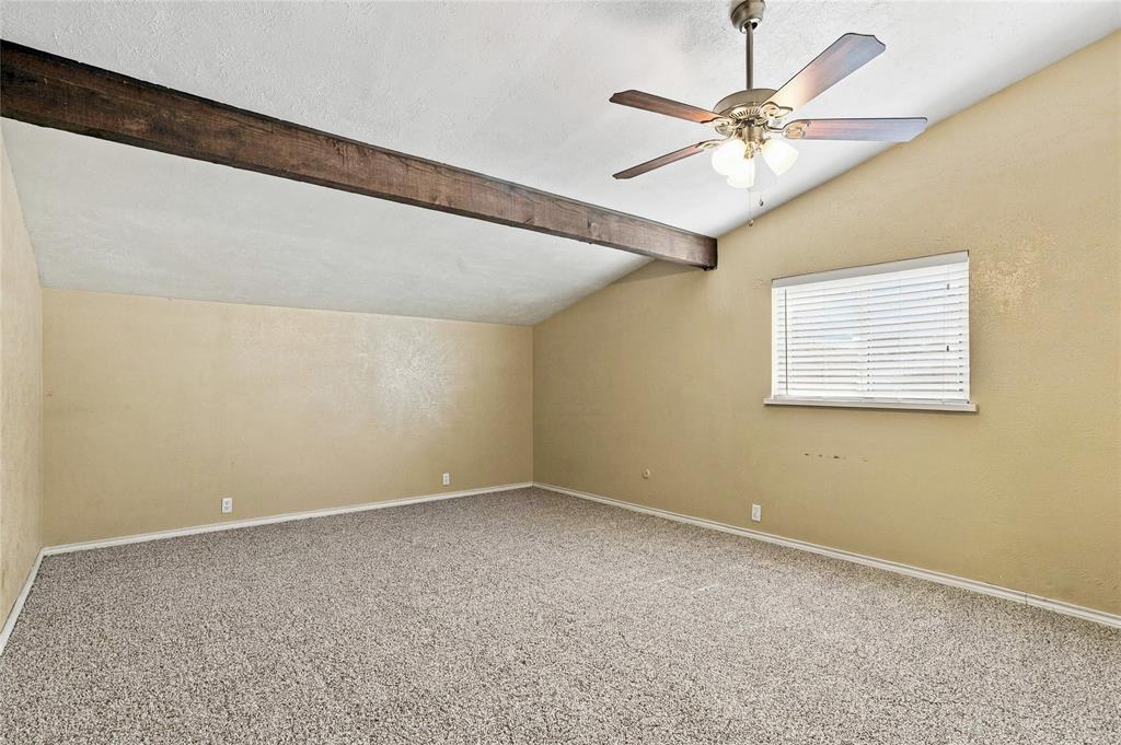 Bedroom featuring neutral walls, carpeted flooring, a ceiling fan, and a large window for natural light.