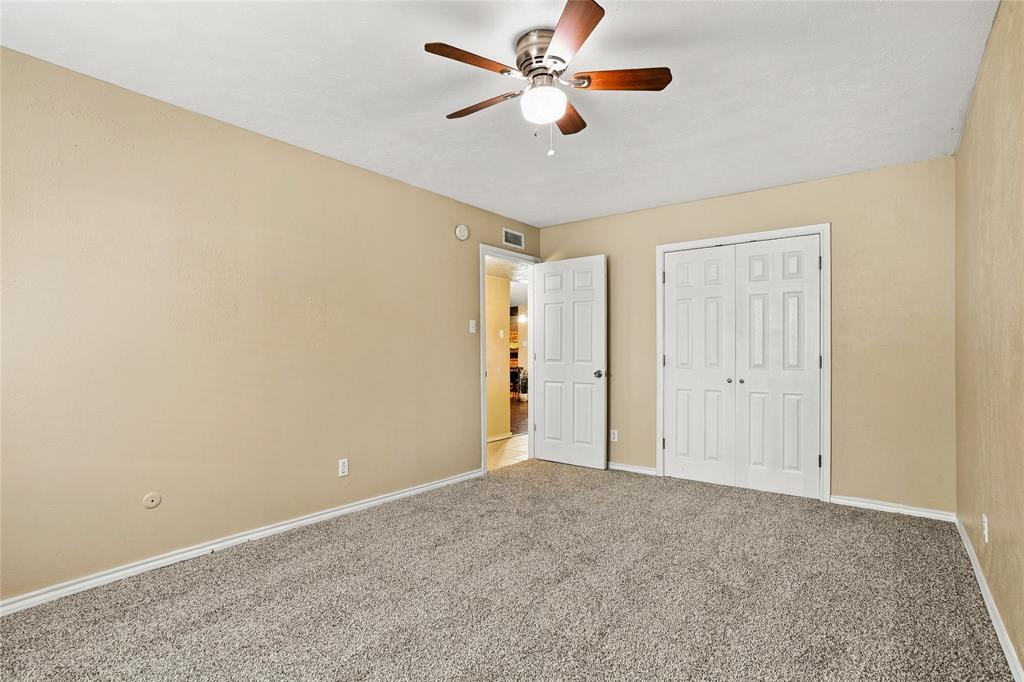 Bedroom with carpeted flooring, neutral finishes, a ceiling fan, and an open layout