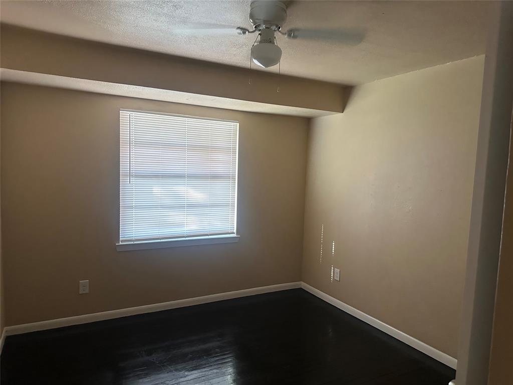 Wood-finish flooring, ceiling fan with integrated lighting, and horizontal window blinds Wood-finish flooring, ceiling fan with integrated lighting, and horizontal window blinds