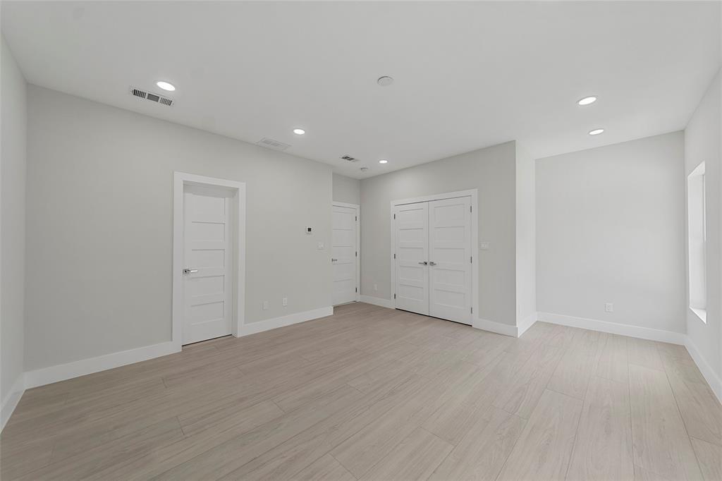 Interior space featuring wood-finish flooring, recessed lighting, and multi-panel interior doors