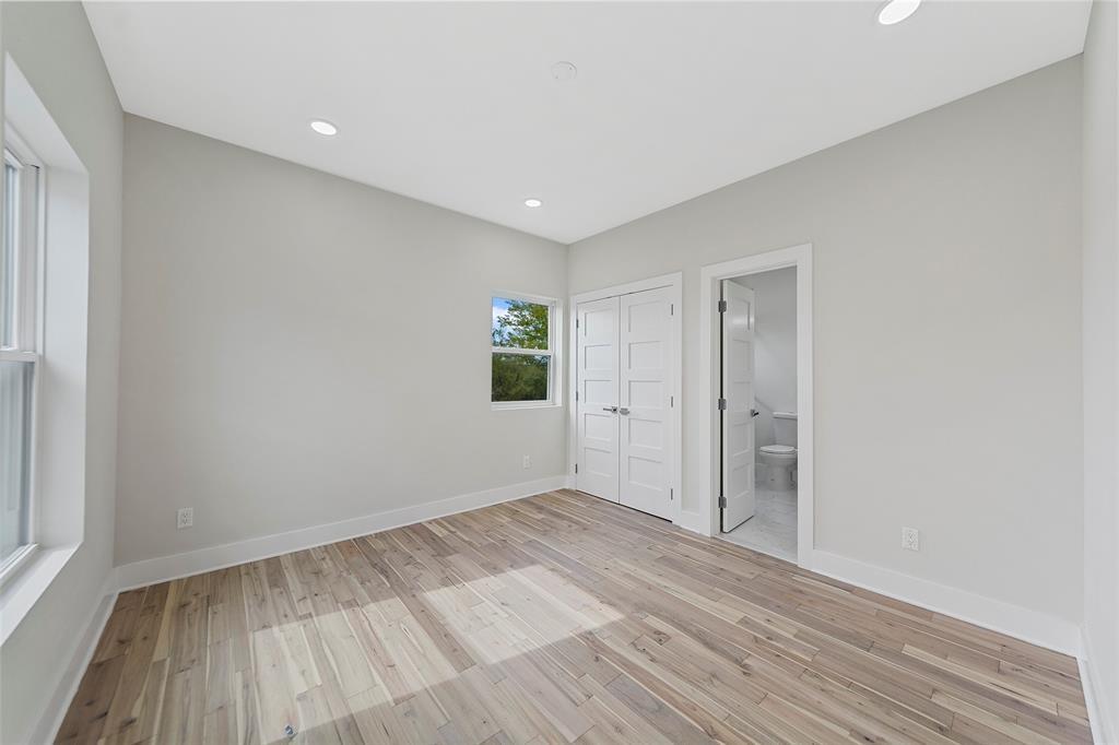 Neutral-toned interior featuring wood-finish flooring, recessed lighting, multi-panel doors, and crisp white trim