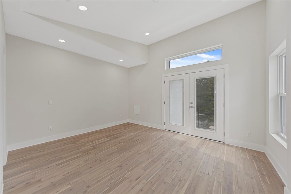 Vaulted ceiling featuring recessed lighting, wood-finish flooring, and glass-paneled double doors topped with a rectangular transom window Vaulted ceiling featuring recessed lighting, wood-finish flooring, and glass-paneled double doors topped with a rectangular transom window