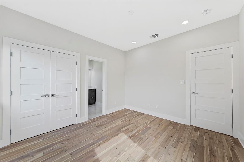 Interior space featuring wood-finish flooring, recessed lighting, and white four-panel doors