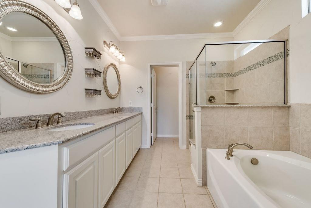 Bathroom with ornamental molding, vanity, tile patterned flooring, and shower with separate bathtub