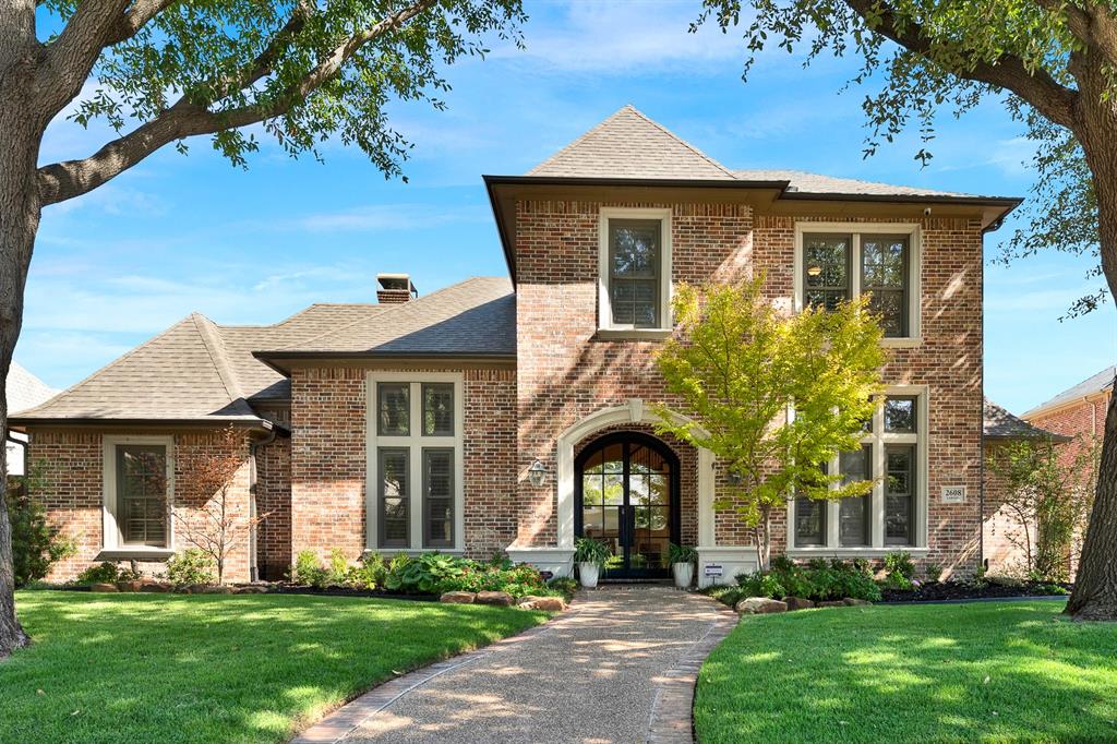 Welcome to 2608 Lawton in Plano.  A grand arched entryway framed in stone accents sets a welcoming tone against a timeless multi-tone brick facade. Imagine strolling down the curved front pathway on a sunny afternoon as dappled light filters through mature shade trees.