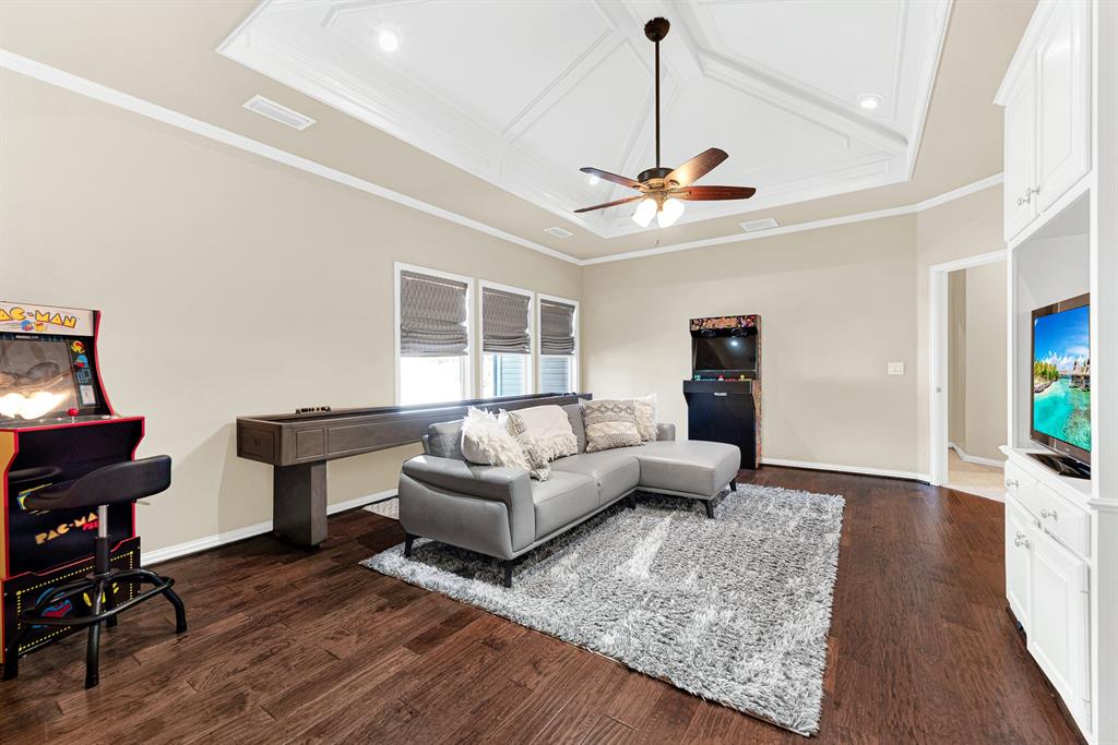A geometric, recessed tray ceiling brings elevated architectural detail to this expansive hardwood lounge. You will love inviting friends over for casual game nights that carry on long after sunset.