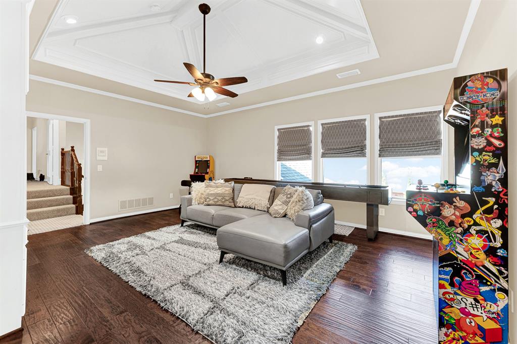 Triple windows framed with woven shades offer peaceful treetop views alongside the rich wood flooring. Imagine spending a cozy rainy afternoon kicking back and enjoying friendly arcade competitions.