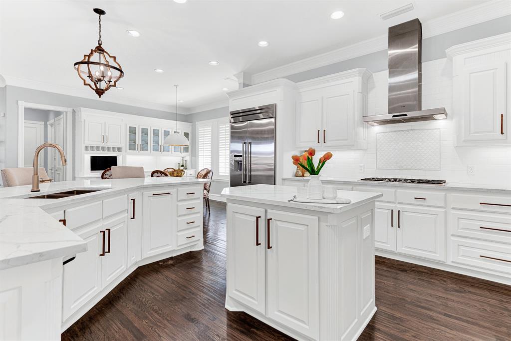 A center Prep island and Thermador professional-grade stainless range hood optimize work flow across rich, dark wood floors. You will love chopping fresh herbs and prepping party appetizers while guests mingle comfortably nearby