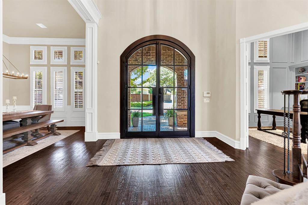 The grand iron-and-glass arched doorway frame fills the hall with soft natural light while offering clear views of the brick entryway. You will love welcoming friends through these glass doors as evening sets in and warm indoor light spill out onto the porch.