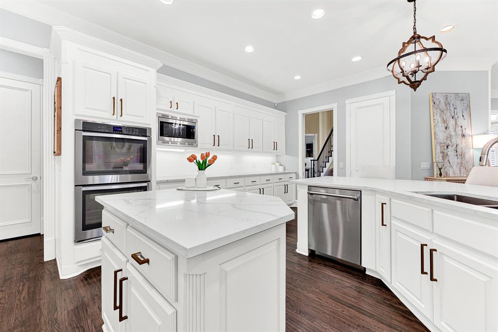 Double walk-in pantry doors integrated into crisp millwork maximize organization alongside high-end stainless appliances. You can easily unpack groceries and stock shelves with ease after a quick afternoon shopping trip.