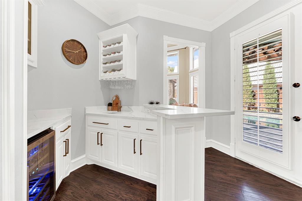 Sleek quartz countertops, wall-mounted wine racks, and an under-counter beverage cooler set the stage beside a glass patio door. You will love mixing signature cocktails or grabbing a chilled drink before stepping outside to enjoy an evening poolside breeze.