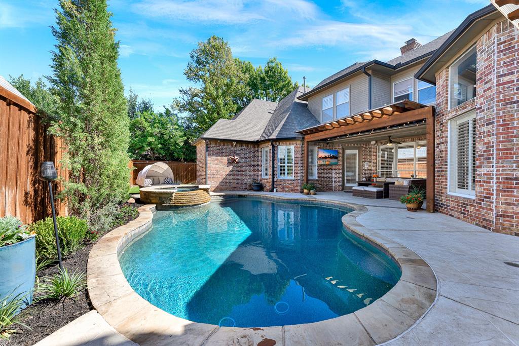 A sprawling covered pergola patio seamlessly bridges the home's rear brick profile with the sparkling swimming pool. Imagine spending relaxed weekend afternoons alternating between swimming laps and lounging in the shade.