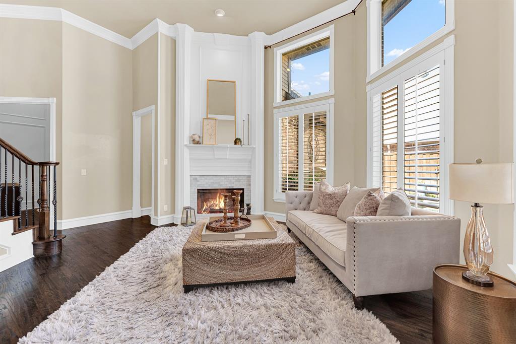 A full-height hearth flanked by custom wall trim draws the eyes up toward the towering, vaulted ceiling line. Picture curling up on a cool autumn night next to a crackling fire, completely cozy and at ease