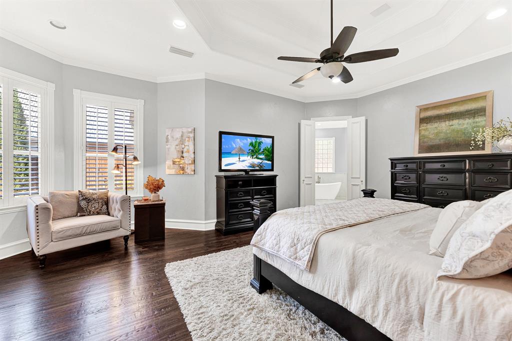 Tall shuttered windows tuck neatly into a angled bay wall, drawing soft natural light across the spacious bedroom layout. It is an ideal nook to curl up with a good book and a warm cup of morning tea.