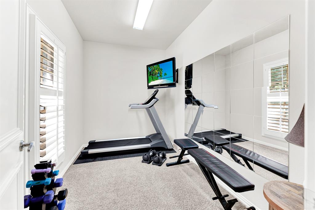 A full-height mirrored accent wall doubles the light and sense of space across neat plush carpeting. It is the ideal private nook to squeeze in a energizing morning workout before starting your daily routine.