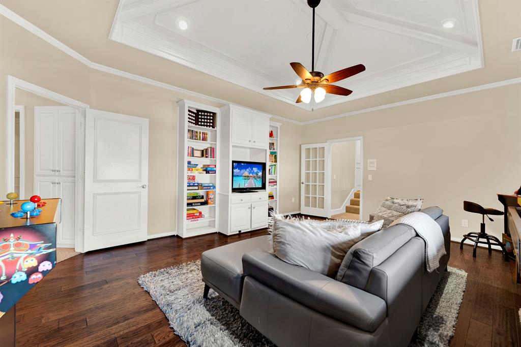 Custom built-in display shelves and French doors establish clean architectural organization within this versatile upper floor retreat. You can easily grab your favorite board games from the built-in storage for a relaxing weekend lounge with family.