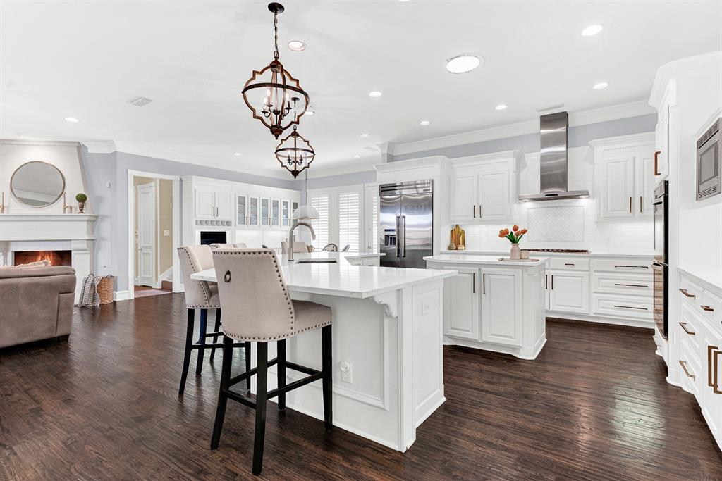 Crisp white quartz countertops and pristine subway tile create an effortless bridge into the adjoined living space. Imagine sipping a hot cup of tea at the counter while listening to the cozy crackle of the family room fire