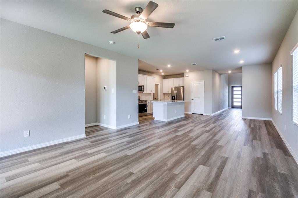 Open-concept interior featuring wood-finish flooring, recessed lighting, a ceiling fan, and a kitchen island with built-in cabinetry