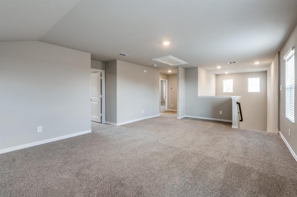 Neutral-toned interior space featuring wall-to-wall carpeting, recessed ceiling lighting, and multiple windows
