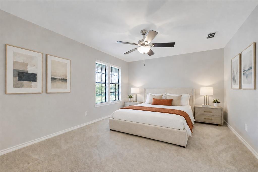 Neutral-toned room featuring neutral wall-to-wall carpeting, a multi-blade ceiling fan with an integrated light fixture, and windows with grid-patterned panes