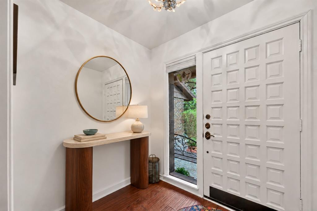 Entryway featuring wood-finish flooring, a multi-panel exterior door with sidelight, and a decorative ceiling fixture Entryway featuring wood-finish flooring, a multi-panel exterior door with sidelight, and a decorative ceiling fixture
