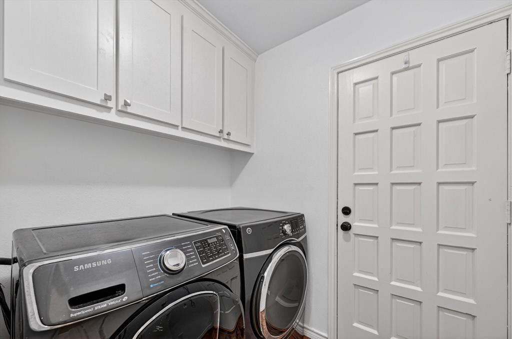 White Shaker-style wall cabinetry with brushed nickel hardware and a multi-panel door with black hardware