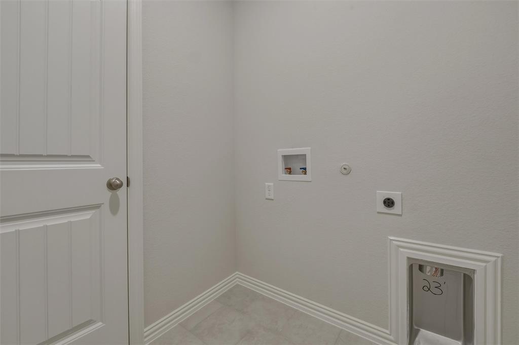 Utility connections with a drain, electrical outlet, water hookups, and a paneled door