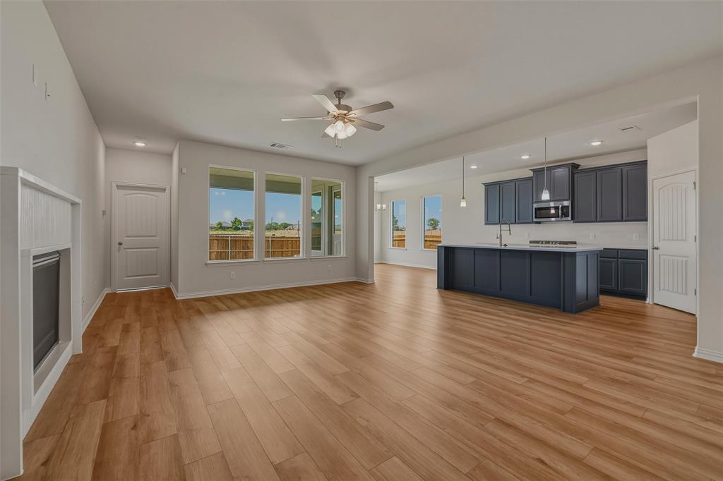 Expansive open-concept living area featuring wood-finish flooring, recessed lighting, and a ceiling fan