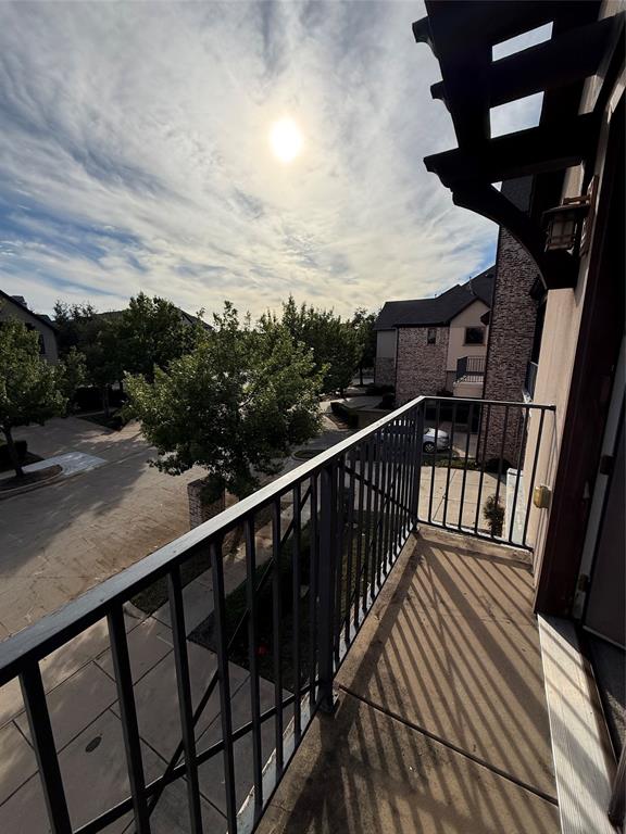 Elevated balcony featuring a metal railing, concrete flooring, and an attached wall-mounted lantern
