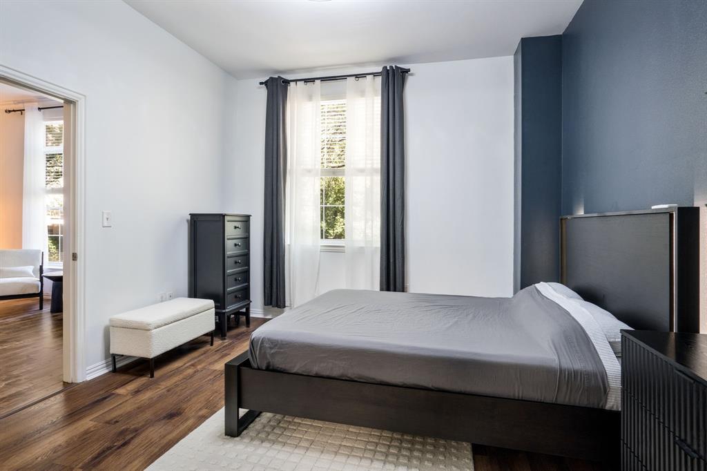 Wood-finish flooring, multi-pane window with grid detailing, and a charcoal accent wall